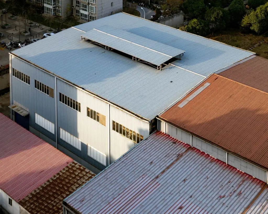 Aerial view of multiple corrugated metal roofs in various colors on industrial buildings in Cypress, TX