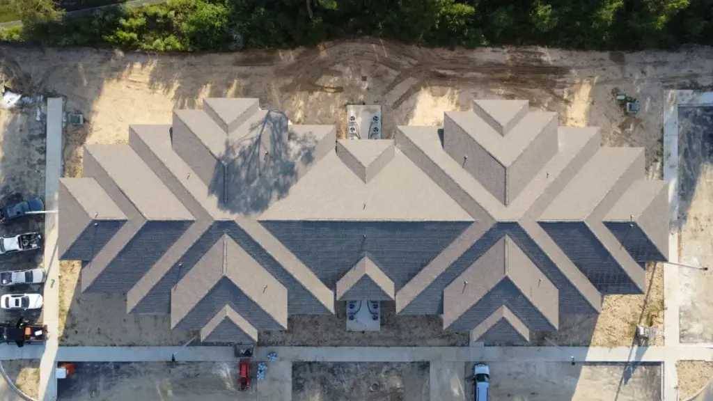 Aerial drone view of a new multi-gable asphalt shingle roof on a residential building under construction in Cypress, TX