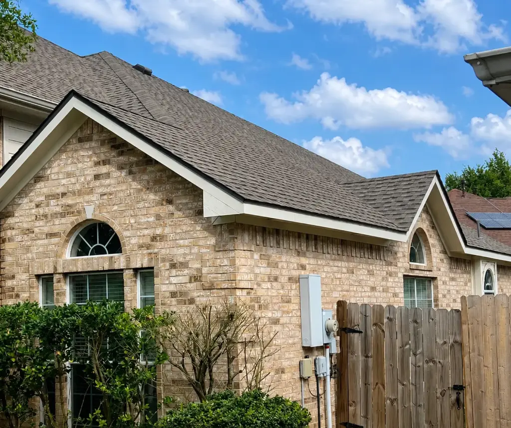 Brick two story home with new dark asphalt shingle roof and double gables in Cypress, TX
